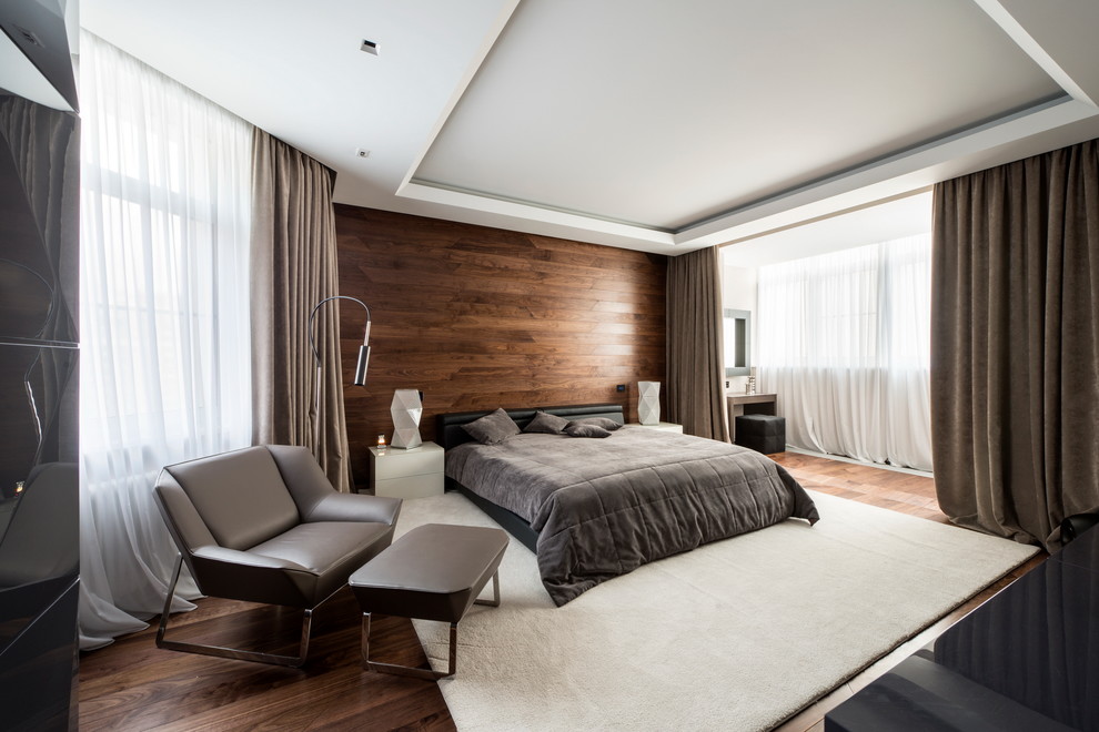 Imagen de dormitorio actual sin chimenea con suelo de madera en tonos medios