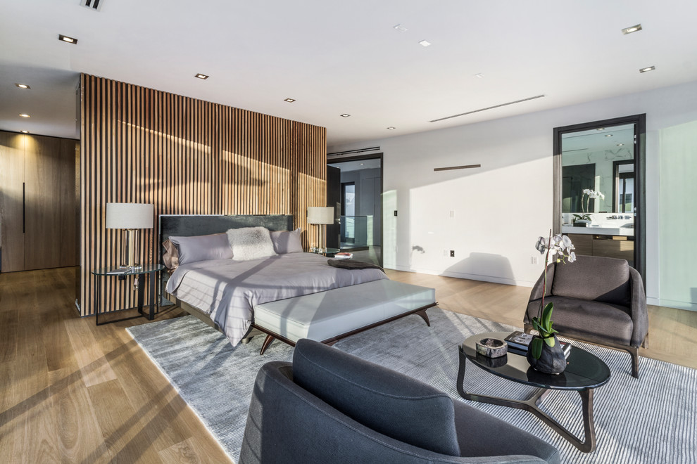 Modernes Hauptschlafzimmer mit weißer Wandfarbe, hellem Holzboden und braunem Boden in Miami