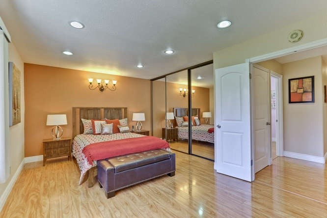 サンフランシスコにある中くらいなミッドセンチュリースタイルのおしゃれな主寝室 (オレンジの壁、淡色無垢フローリング) のインテリア