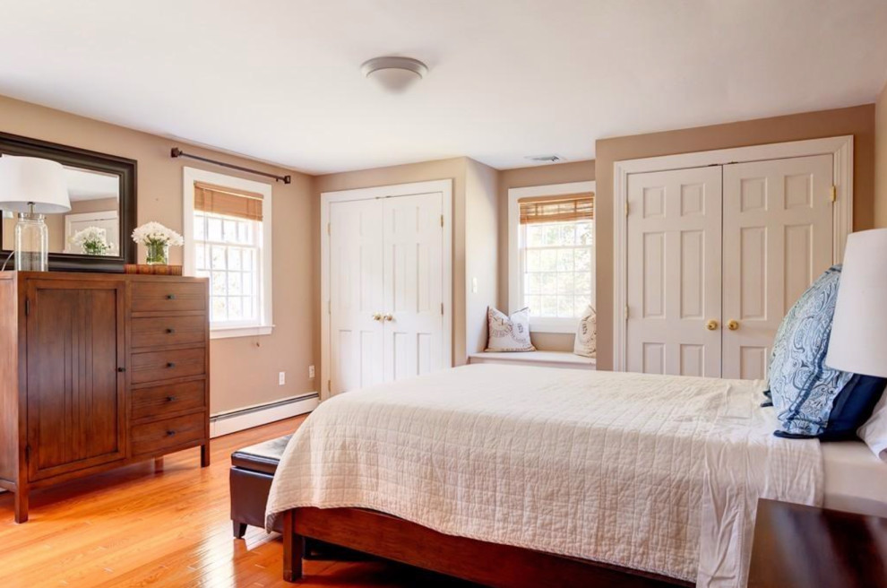 Ispirazione per una camera degli ospiti chic di medie dimensioni con pareti beige e pavimento in legno massello medio