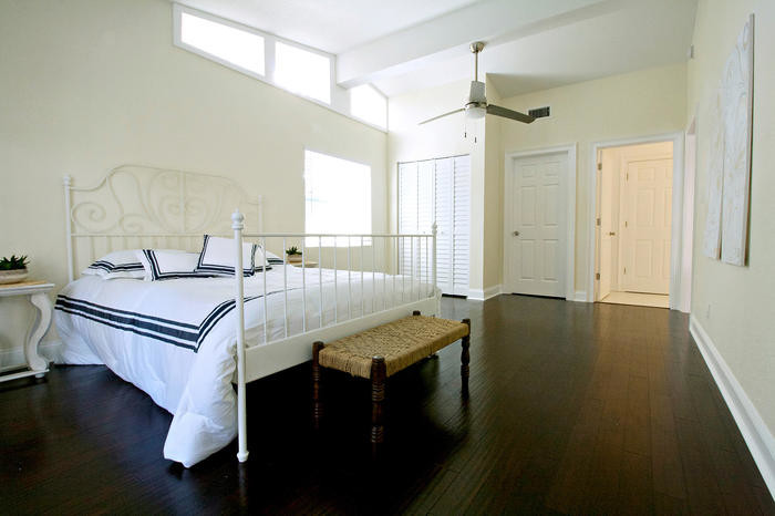 Стильный дизайн: большая хозяйская спальня в классическом стиле с желтыми стенами и полом из бамбука - последний тренд