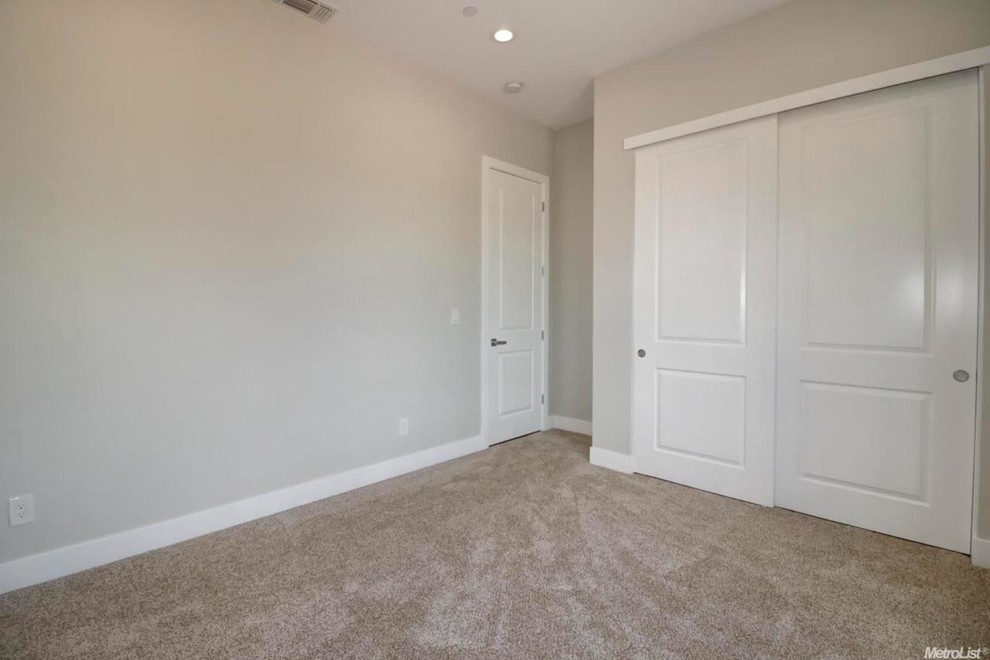 Immagine di una camera matrimoniale minimal di medie dimensioni con pareti grigie, moquette e pavimento grigio