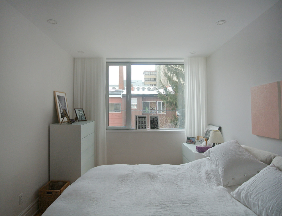 Kleines Modernes Schlafzimmer ohne Kamin mit weißer Wandfarbe, hellem Holzboden und beigem Boden in Montreal
