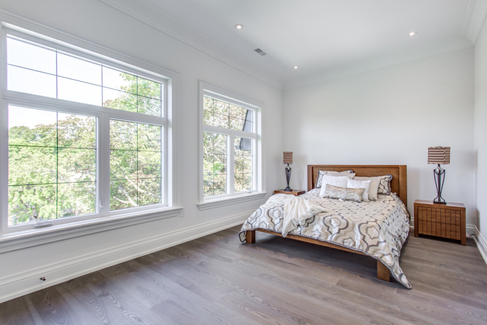 Bedroom - huge contemporary master medium tone wood floor and gray floor bedroom idea in Toronto with white walls, a standard fireplace and a plaster fireplace
