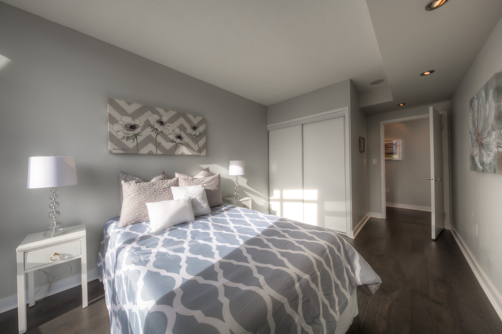 На фото: гостевая спальня среднего размера, (комната для гостей) в стиле модернизм с серыми стенами и темным паркетным полом