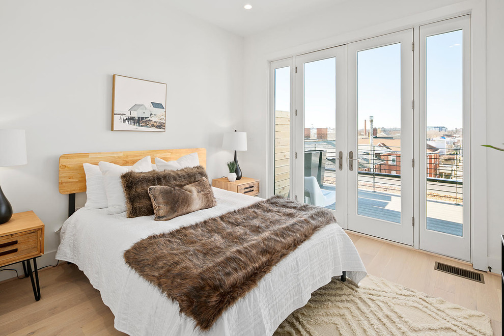 На фото: спальня в скандинавском стиле с белыми стенами и светлым паркетным полом без камина с
