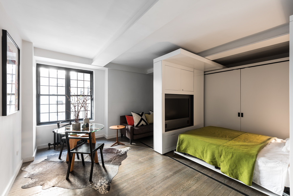 Ispirazione per una piccola camera da letto moderna con pareti bianche e pavimento in legno massello medio