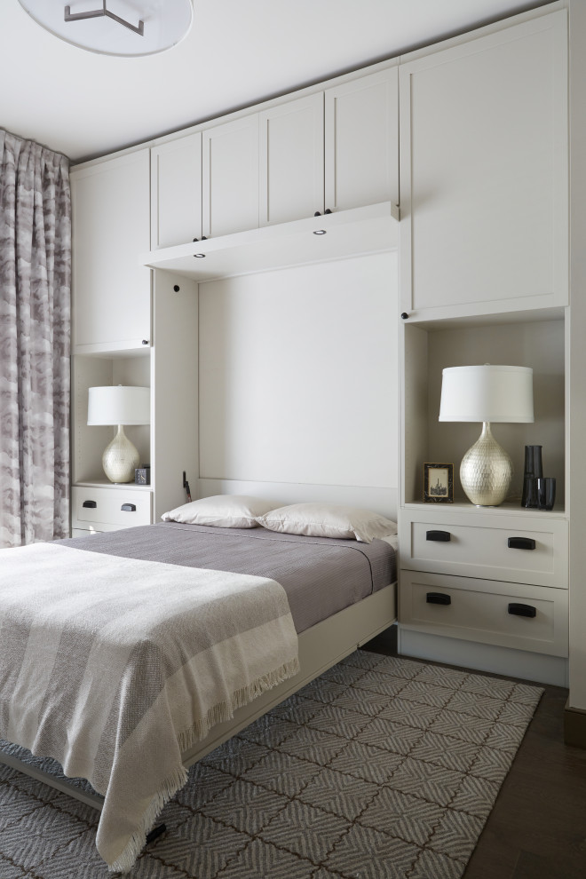 Cette photo montre une chambre d'amis chic avec parquet foncé, un sol marron et un mur blanc.