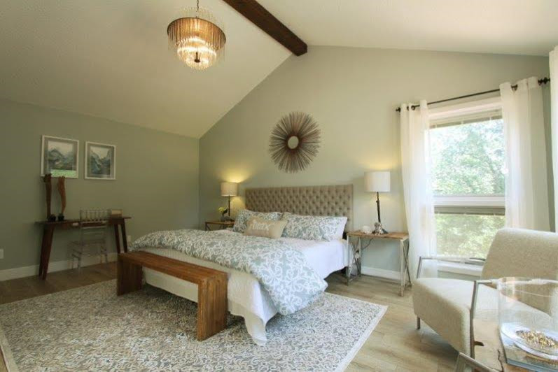 Стильный дизайн: большая хозяйская спальня в стиле рустика с зелеными стенами и полом из винила - последний тренд