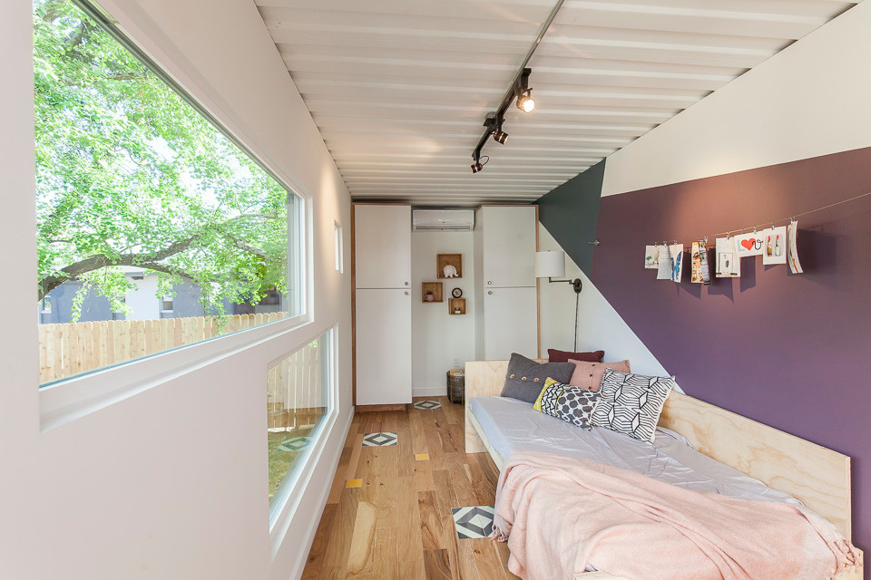 Idée de décoration pour une chambre d'amis design de taille moyenne avec un mur blanc, parquet clair, aucune cheminée et un sol multicolore.