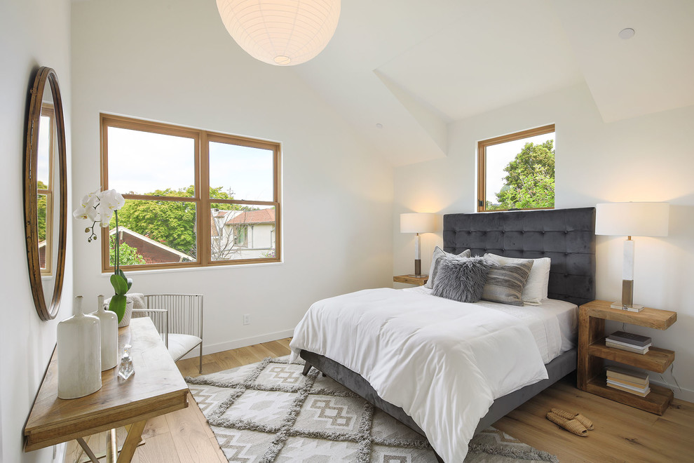 Foto di una camera da letto minimal con pareti bianche, pavimento in legno massello medio e pavimento marrone