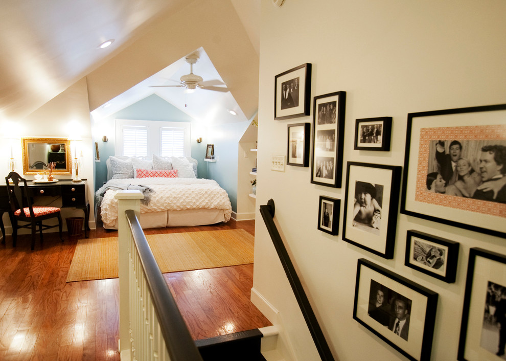 Exemple d'une chambre mansardée ou avec mezzanine éclectique de taille moyenne avec un mur bleu, un sol en bois brun et aucune cheminée.