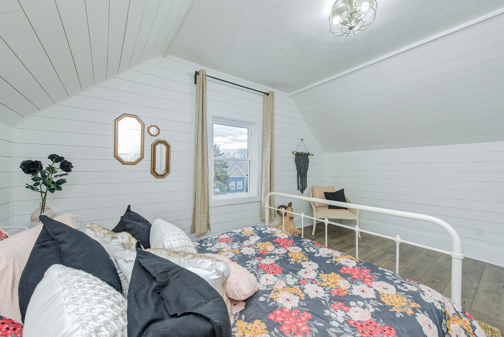 Ejemplo de dormitorio tipo loft campestre de tamaño medio sin chimenea con paredes blancas, suelo de madera clara y suelo marrón