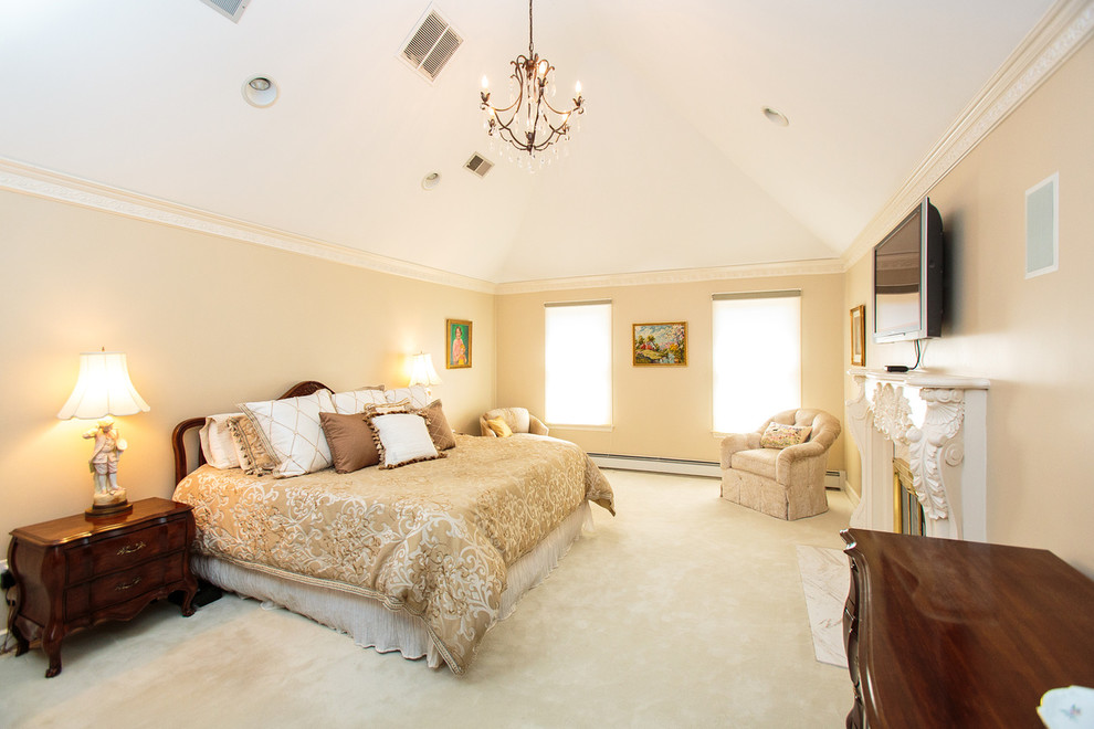 Ejemplo de dormitorio principal clásico grande con paredes beige, moqueta, todas las chimeneas y marco de chimenea de yeso