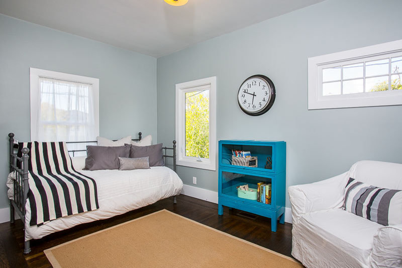 Diseño de habitación de invitados clásica pequeña con paredes azules y suelo de madera oscura