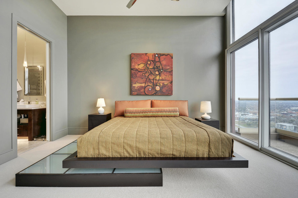 This is an example of a contemporary master bedroom in Austin with grey walls and carpet.