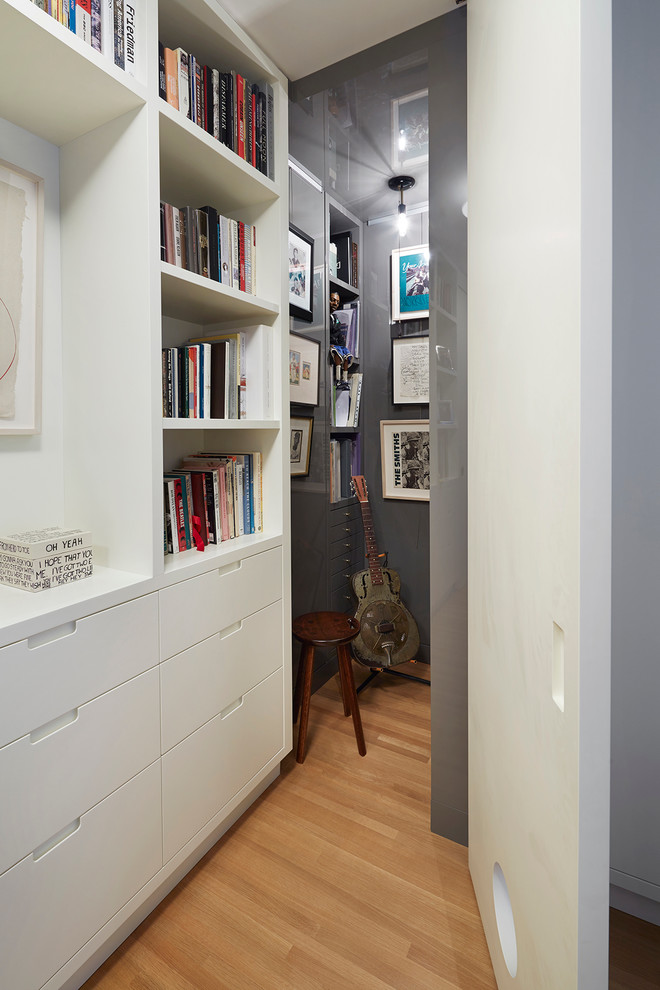 Ejemplo de dormitorio minimalista de tamaño medio sin chimenea con paredes grises y suelo de madera en tonos medios