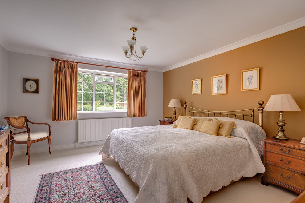 Klassisches Schlafzimmer mit oranger Wandfarbe und Teppichboden in Devon