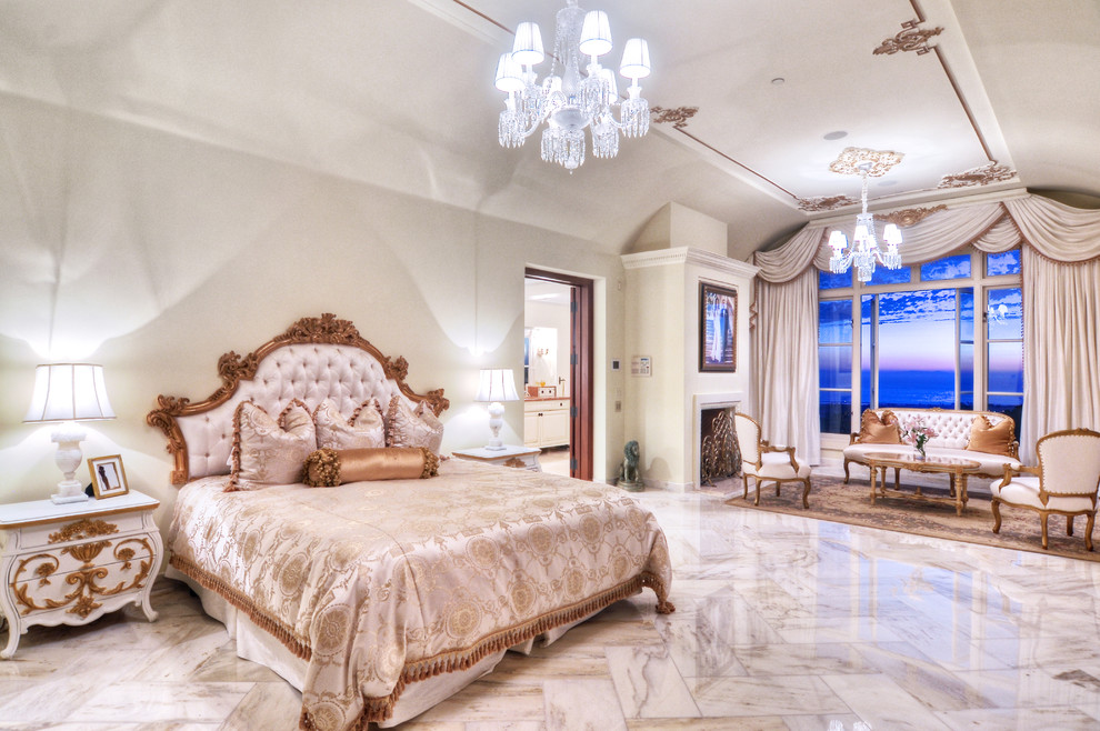 Imagen de dormitorio principal mediterráneo grande con paredes blancas, suelo de travertino y todas las chimeneas
