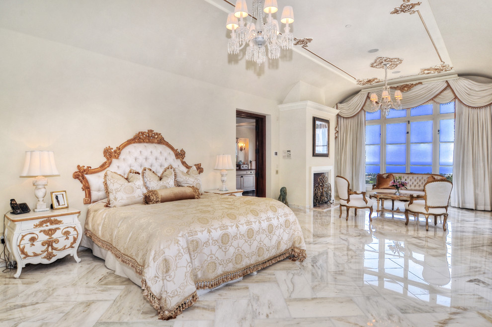 Idee per una grande camera matrimoniale mediterranea con pareti bianche, pavimento in travertino e camino classico