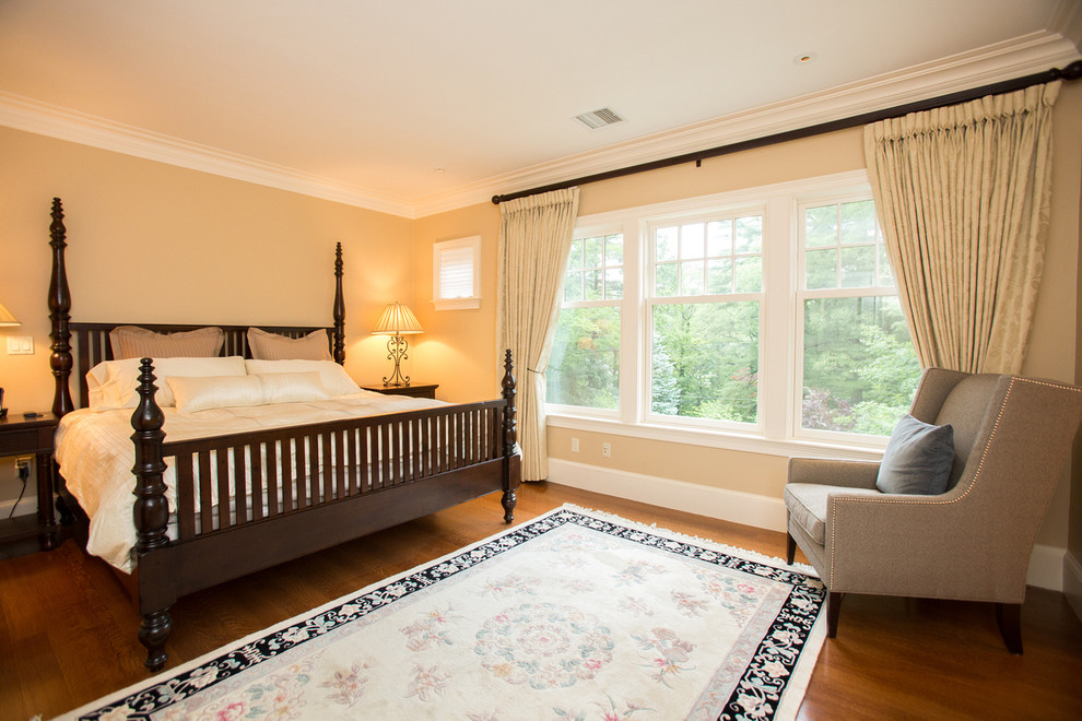 Klassisches Gästezimmer mit beiger Wandfarbe und braunem Holzboden in Boston