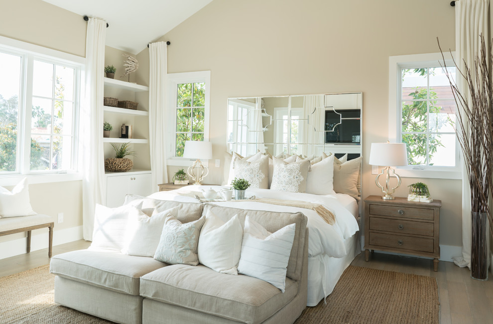 Maritimes Hauptschlafzimmer mit beiger Wandfarbe und hellem Holzboden in Orange County