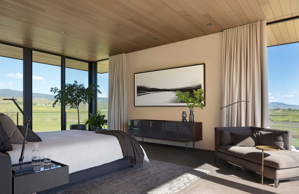 На фото: спальня в современном стиле с бежевыми стенами, бетонным полом и серым полом