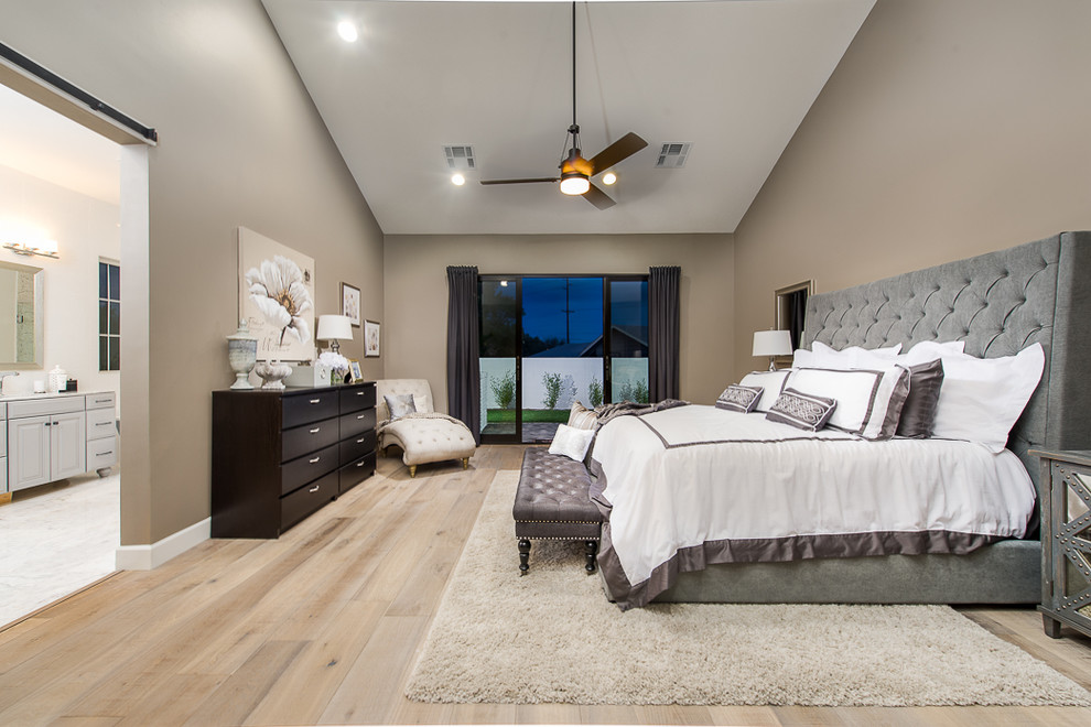 Foto de dormitorio principal tradicional renovado grande sin chimenea con paredes grises y suelo de madera clara