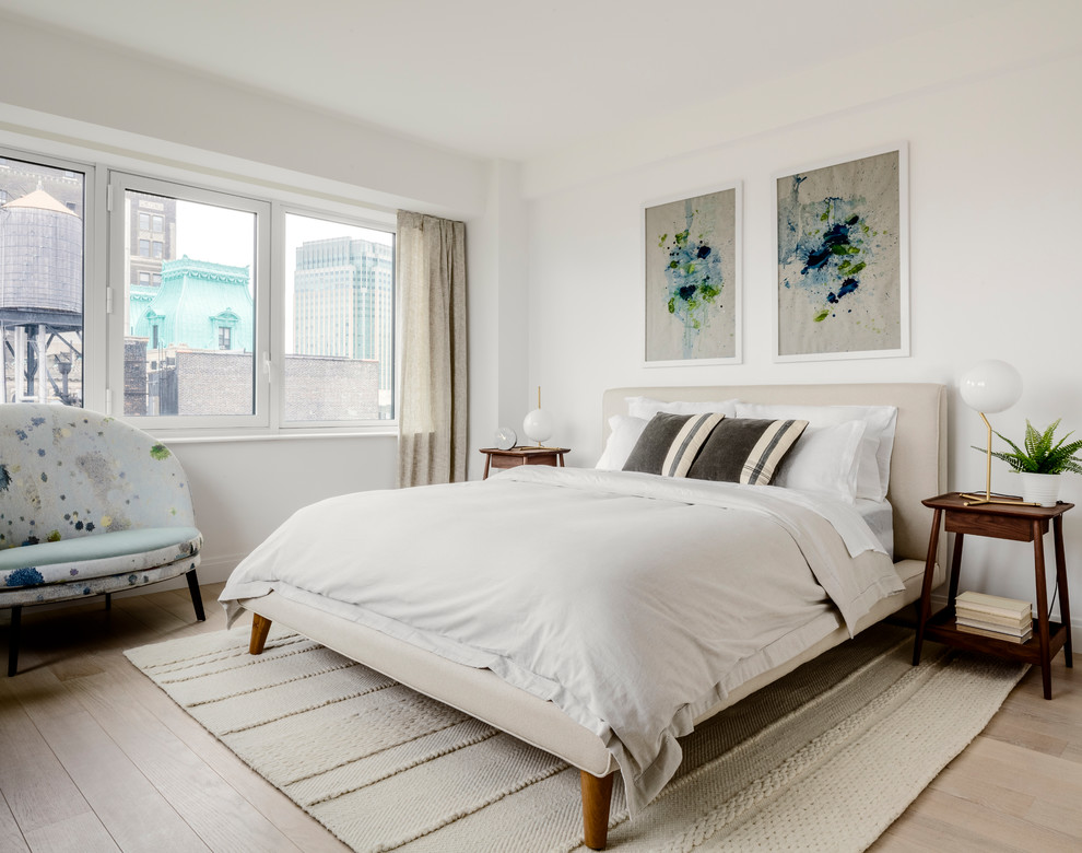Modelo de dormitorio escandinavo sin chimenea con paredes blancas y suelo de madera clara
