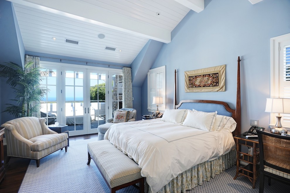 Réalisation d'une chambre parentale marine avec un mur bleu, parquet foncé et un sol marron.