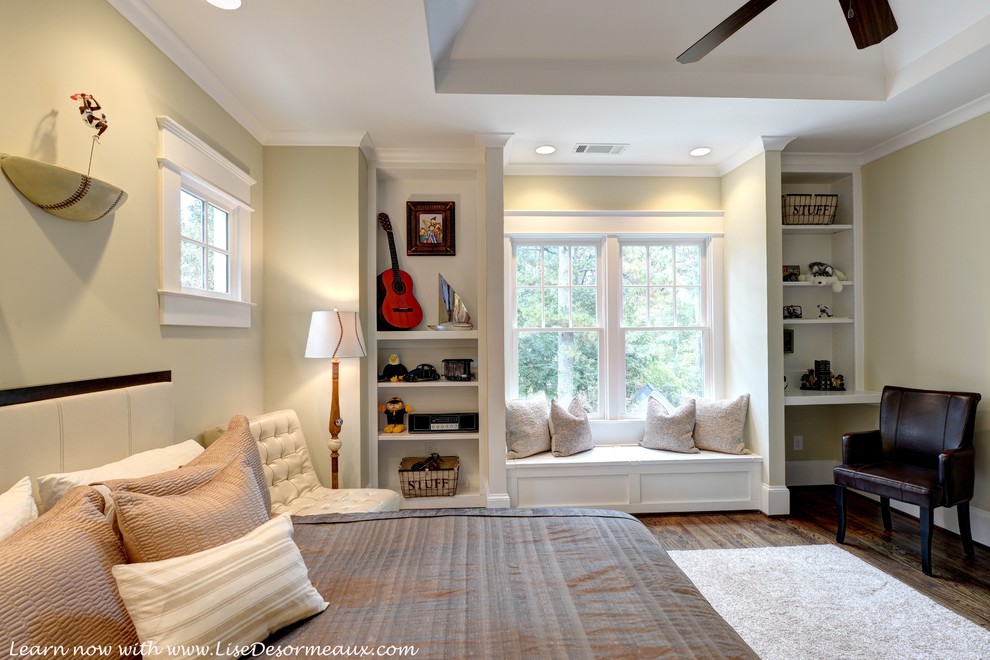 Immagine di un'ampia camera da letto american style con pareti beige e pavimento in legno massello medio