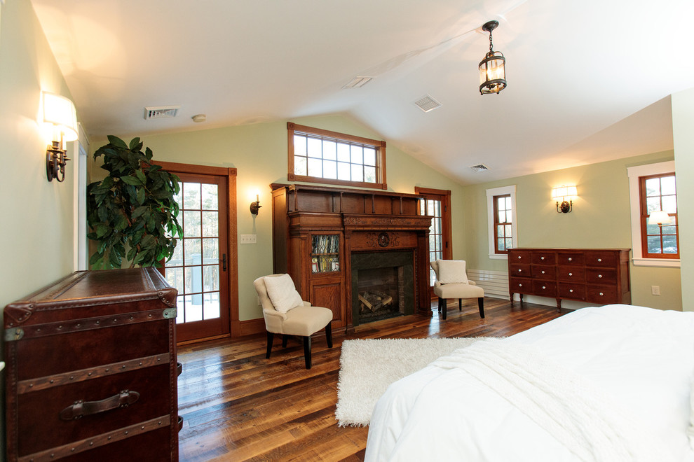Imagen de dormitorio principal tradicional grande con paredes verdes, suelo de madera oscura, todas las chimeneas y marco de chimenea de madera