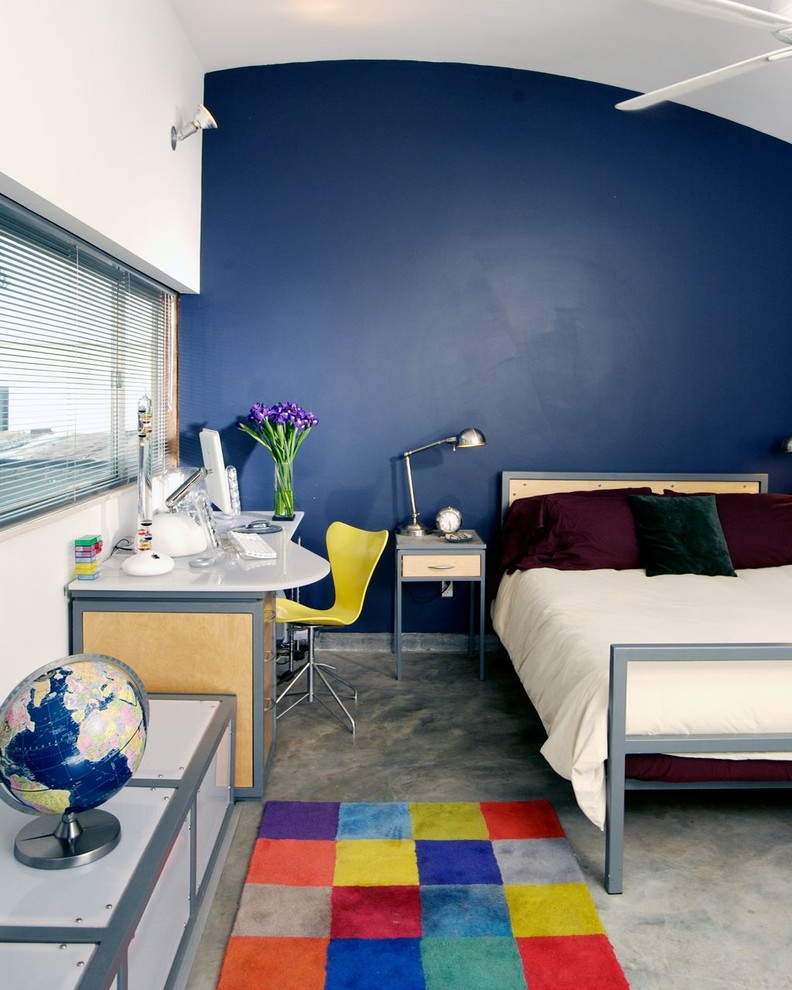 Ejemplo de dormitorio moderno con suelo de cemento y con escritorio