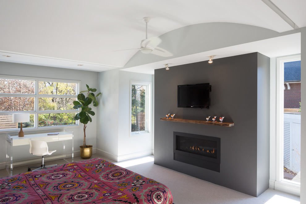 Стильный дизайн: хозяйская спальня среднего размера в современном стиле с серыми стенами, ковровым покрытием, горизонтальным камином и фасадом камина из штукатурки - последний тренд
