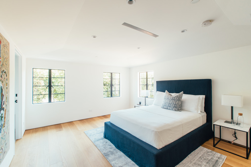 Ejemplo de dormitorio principal actual con paredes blancas, suelo de madera en tonos medios y suelo beige