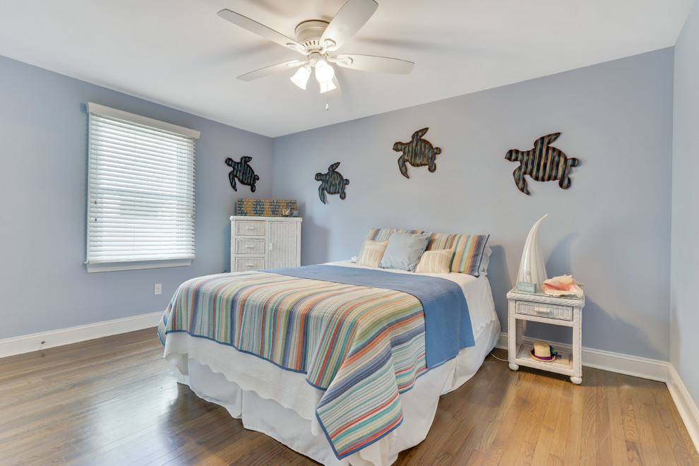На фото: гостевая спальня среднего размера, (комната для гостей) в морском стиле с синими стенами, паркетным полом среднего тона и синим полом без камина с