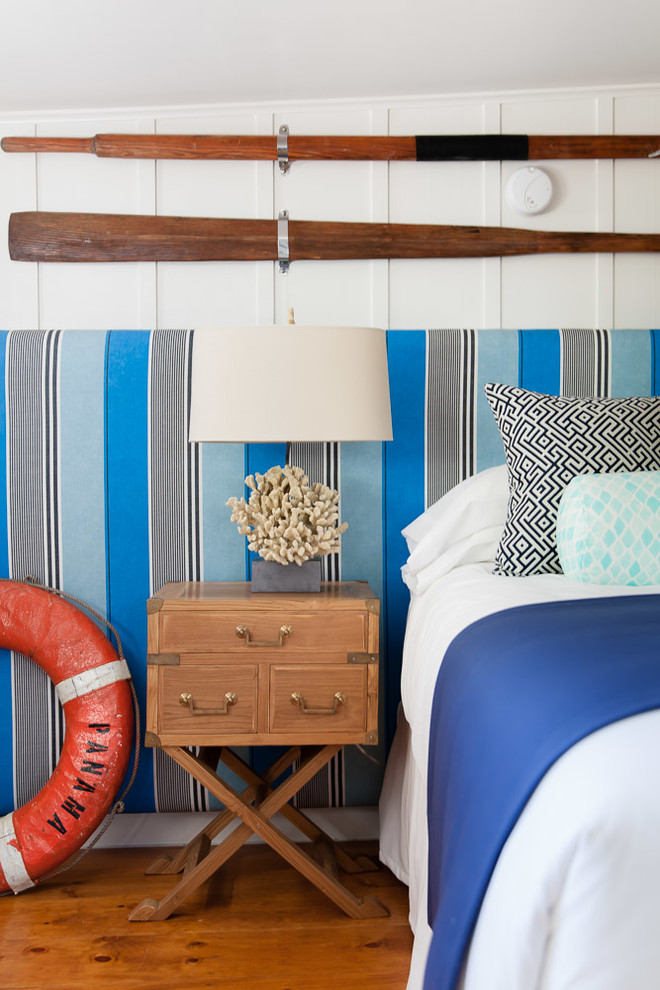Foto de dormitorio costero de tamaño medio sin chimenea con paredes blancas y suelo de madera clara