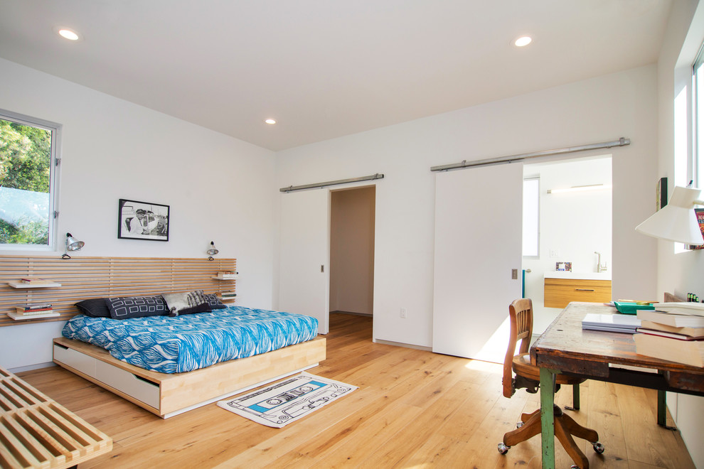 Modelo de habitación de invitados contemporánea con paredes blancas y suelo de madera en tonos medios