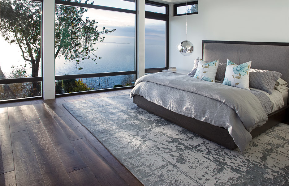 Diseño de dormitorio principal minimalista con paredes blancas y suelo de madera en tonos medios