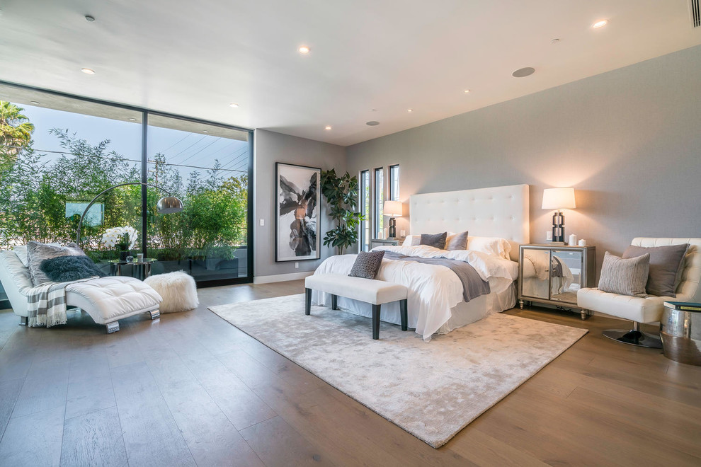 ロサンゼルスにある広いコンテンポラリースタイルのおしゃれな主寝室 (グレーの壁、淡色無垢フローリング、暖炉なし、茶色い床、グレーとブラウン) のインテリア