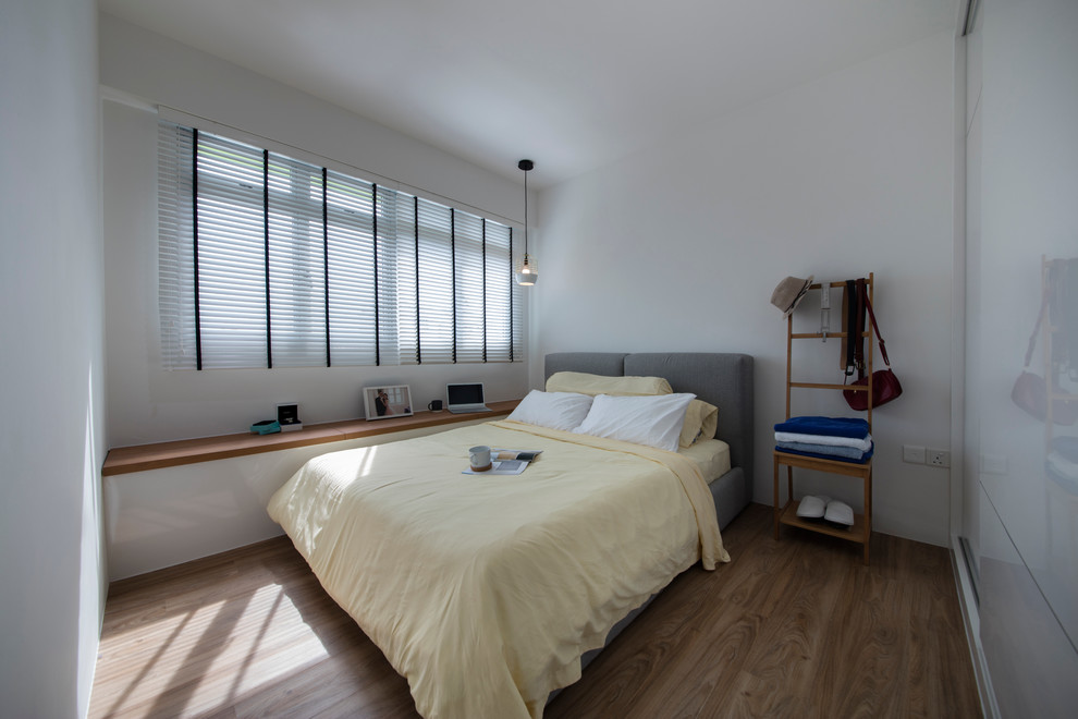Diseño de dormitorio principal actual pequeño con paredes blancas y suelo de madera clara