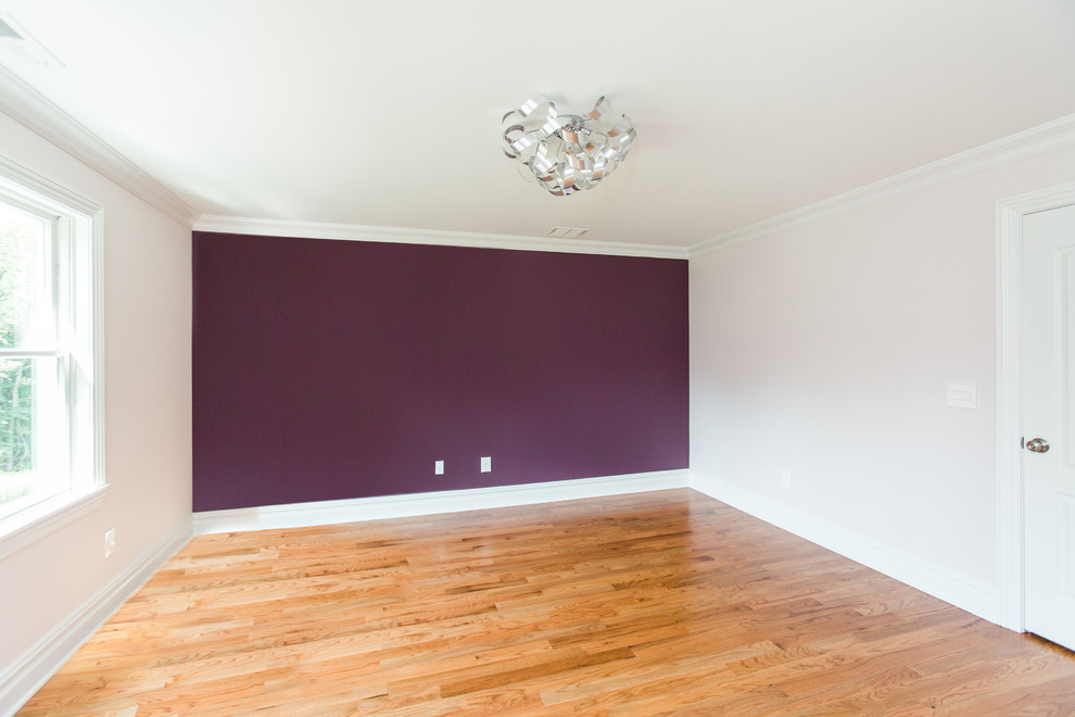 Cette photo montre une grande chambre d'amis chic avec un mur violet, un sol en bois brun, un sol marron et aucune cheminée.