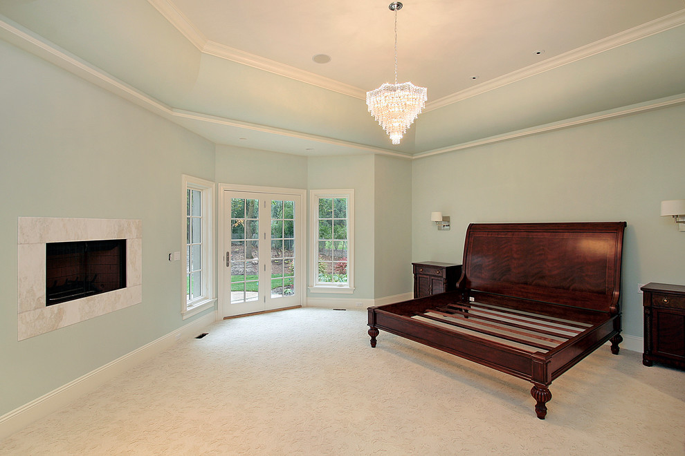 Idée de décoration pour une grande chambre tradition avec un mur bleu, une cheminée ribbon, un manteau de cheminée en pierre et un sol beige.