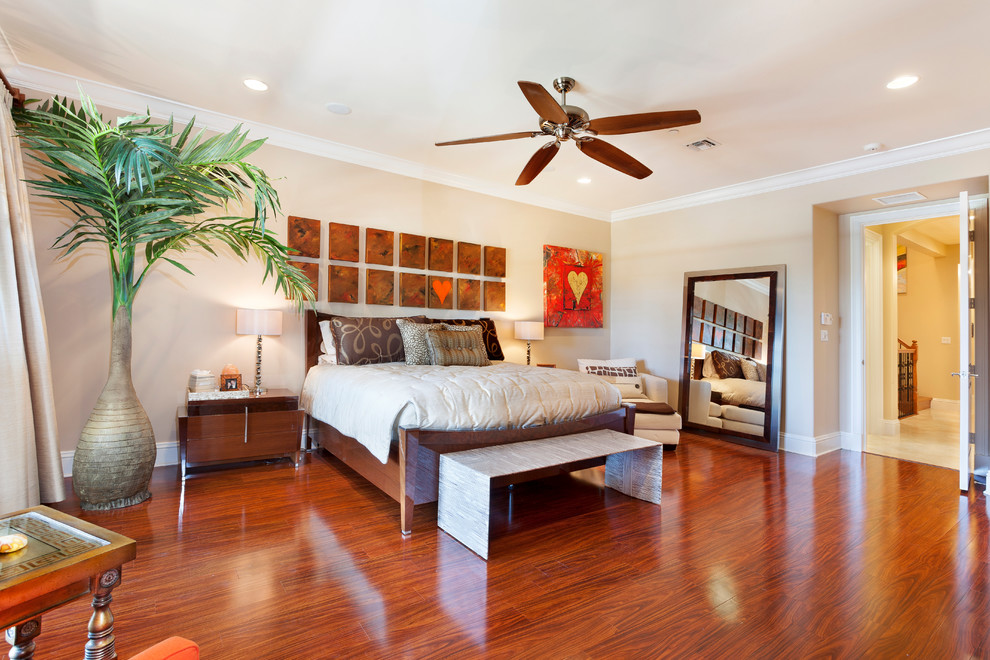 Diseño de dormitorio principal exótico grande sin chimenea con paredes beige, suelo de madera en tonos medios y suelo marrón
