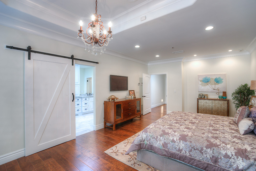 Modelo de habitación de invitados de estilo americano de tamaño medio sin chimenea con paredes beige y suelo de madera en tonos medios