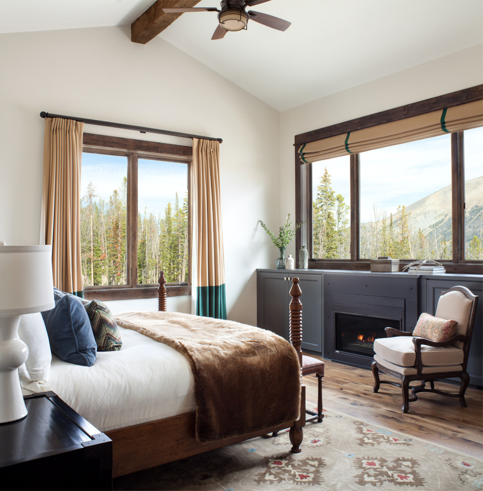 Imagen de dormitorio abovedado rural con paredes beige, suelo de madera en tonos medios y suelo marrón