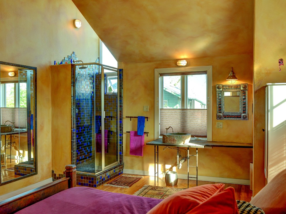 Eklektisches Schlafzimmer mit gelber Wandfarbe und braunem Holzboden in Austin