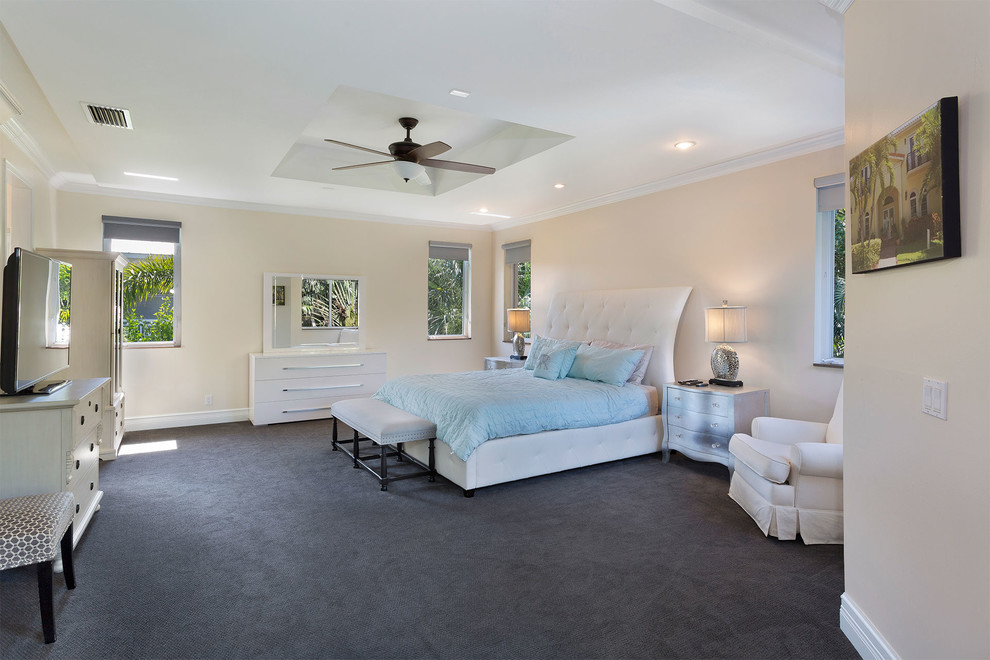 マイアミにある中くらいな地中海スタイルのおしゃれな客用寝室 (ベージュの壁、カーペット敷き、暖炉なし、グレーの床) のインテリア