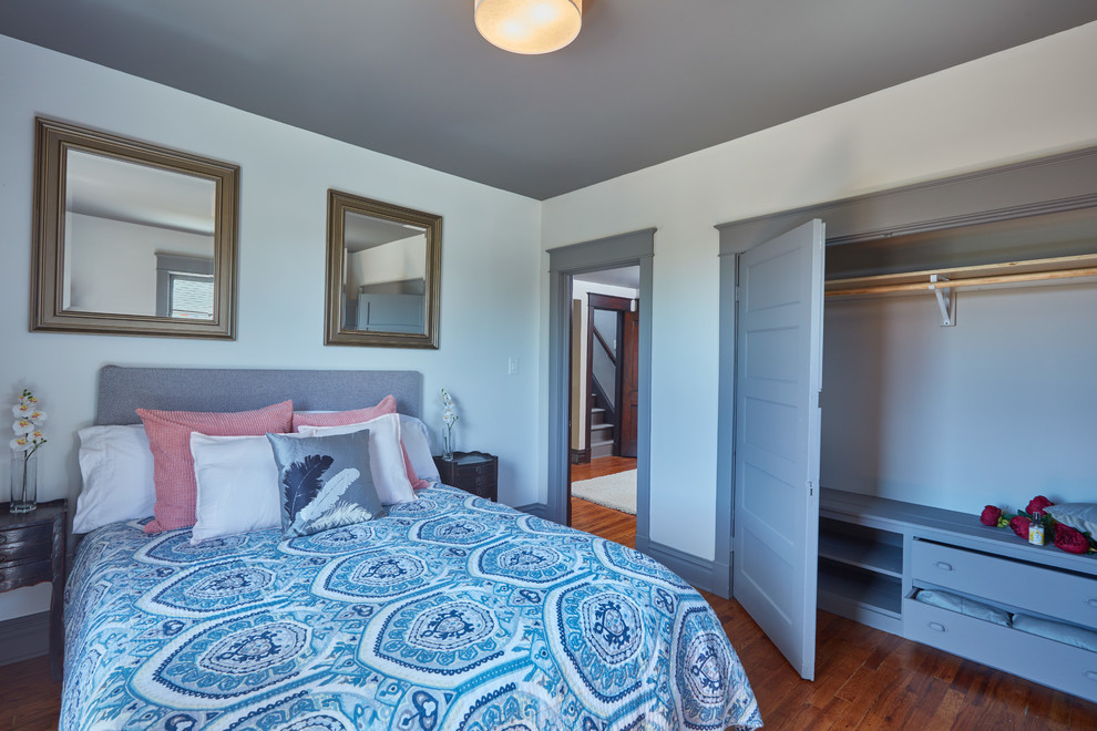 Mittelgroßes Modernes Hauptschlafzimmer ohne Kamin mit weißer Wandfarbe und braunem Holzboden in Kansas City