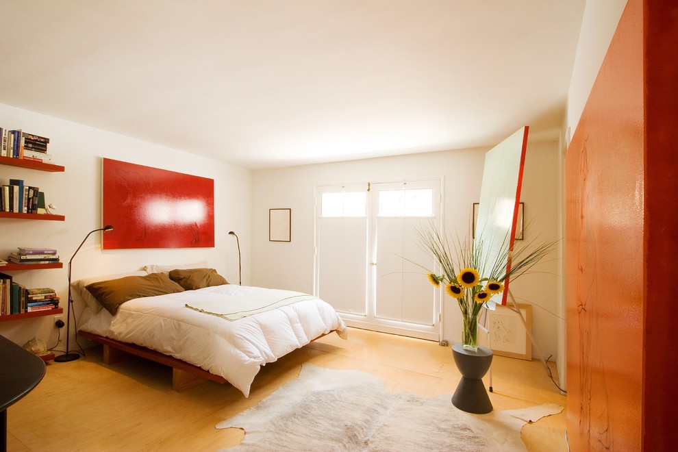 Immagine di una camera da letto design con pavimento in compensato e pavimento giallo